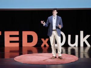 student presenting at TedX Duke stage